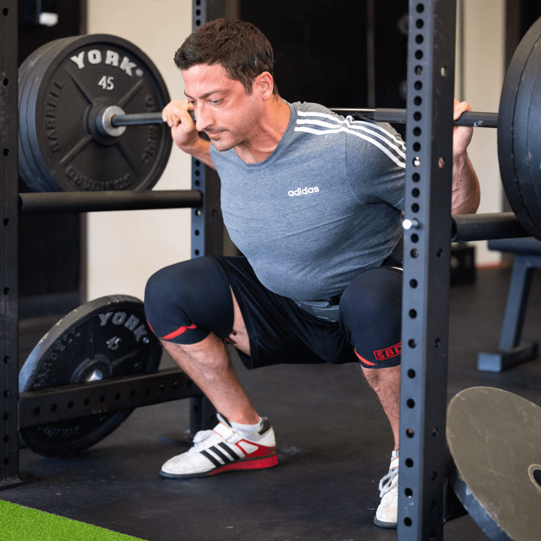 Man squatting in knee sleeves